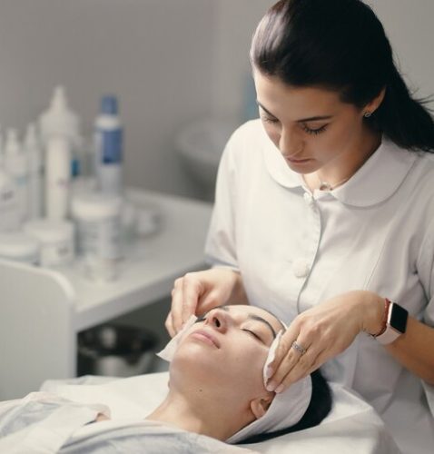 female-cosmetologist-making-facial-treatment-beautiful-woma_158595-4587
